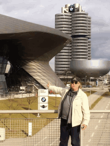 a man standing in front of a bmw group sign