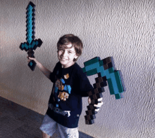 a boy wearing a shirt that says minecraft is holding a diamond sword and an axe