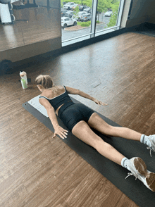 a woman laying on a yoga mat with her legs outstretched