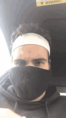 a man with a bandage on his head wearing a black mask and a headband