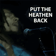 a man singing into a microphone with the words put the heathen back