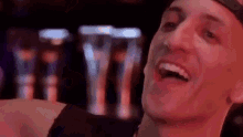 a close up of a man laughing with his mouth open in a bar .