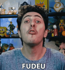 a man making a funny face with the word fudeu on his shirt