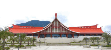 a large building with a red roof that says ' hong kong ' on it is surrounded by palm trees