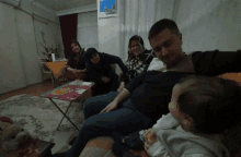 a group of people are sitting on a couch with a baby