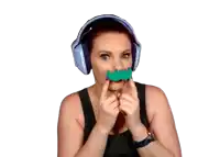 a woman wearing headphones and holding a fake mustache in front of her mouth