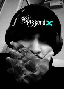 a black and white photo of a person wearing a black hat that says blazzard x