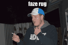 a man smoking a cigarette and wearing a faze rug sweatshirt