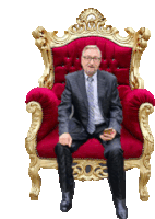 a man in a suit and tie is sitting on a red and gold chair