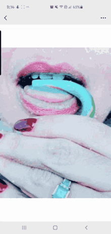 a close up of a woman 's mouth with a lollipop in her mouth .