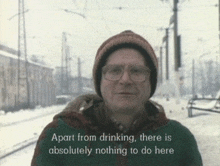 a man wearing glasses and a hat says apart from drinking there is absolutely nothing to do here ..