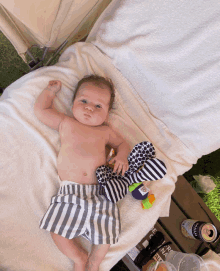 a baby is laying on a towel next to a can of citra ale