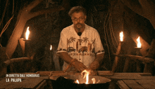 a man standing in front of a fire with the words in diretta dall honduras la palapa on the bottom