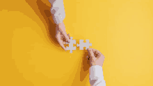 a man and a woman are holding pieces of a puzzle together on a yellow background