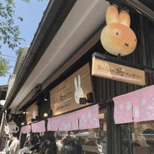 a sign for miffy sakura bakery hangs above a storefront