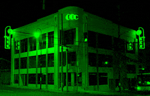 a building with the letter cc on it is lit up in green