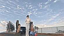 a woman in a bikini is standing next to a man and a car