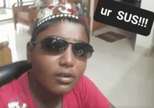 a young boy wearing sunglasses and a crown says " ur sus "