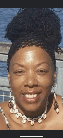 a close up of a woman wearing a necklace and earrings .