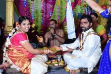 a man is singing into a microphone while a woman holds a bowl of food in front of them