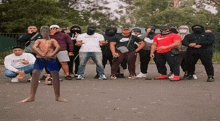 a man in a nike shirt stands in front of a group of masked men