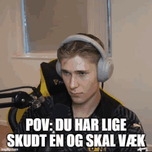 a young man wearing headphones is sitting in front of a microphone with the caption pov du har lige skudt en og skal vek