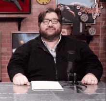 a man sitting in front of a microphone with a sign above him that says " arguing over truth "