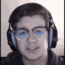 a young man wearing glasses and headphones with the watermark kinemaster