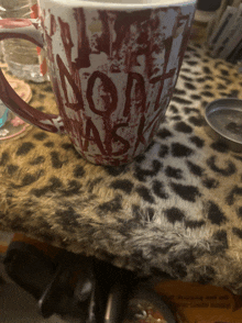 a bloody mug that says " do not ask " is on a table