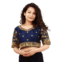 a woman wearing a blue blouse with gold embroidery on the sleeves