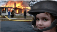 a girl wearing a helmet stands in front of a fire