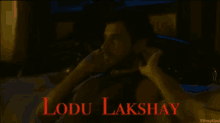 a man laying on a bed with the name lodu lakshay written on the bottom