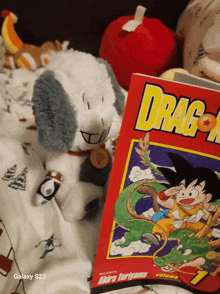 a stuffed animal sits next to a dragon ball book