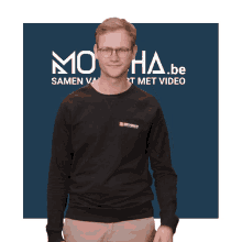 a man stands in front of a sign that says moha.be