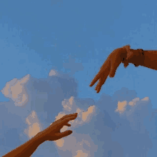 two hands reaching out towards each other in front of a blue sky with clouds .