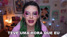 a woman with green hair has a butterfly on her face and the words teve uma hora que eu below her