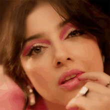 a close up of a woman with pink makeup on her face