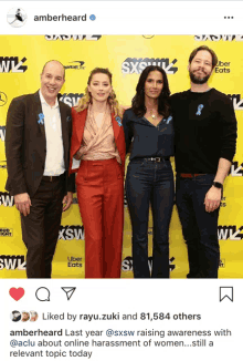 a group of people standing in front of a yellow wall that says sxsw on it