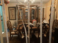 a dining room with a table and chairs decorated with ribbons that say happy birthday