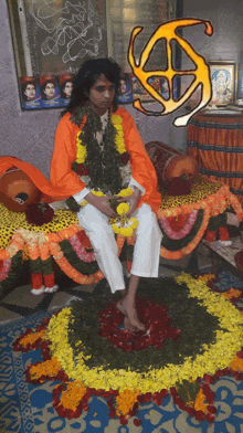 a man in an orange robe sits on a bed with flowers on it