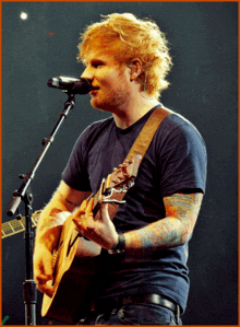 a man singing into a microphone and holding a guitar