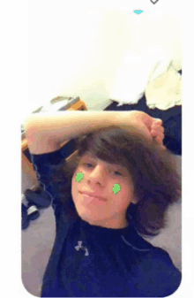 a young boy with a sticker on his face that looks like a clover