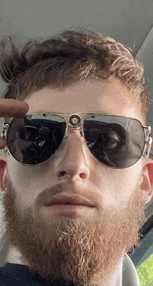 a man with a beard wears a pair of sunglasses