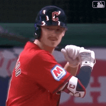 a baseball player is getting ready to bat while wearing a red jersey with the letter c on it .