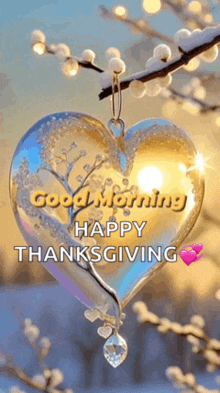 a heart shaped ornament hanging from a tree branch with the words `` good morning happy thanksgiving '' .