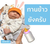 a baby is being held by a person with a bottle of milk