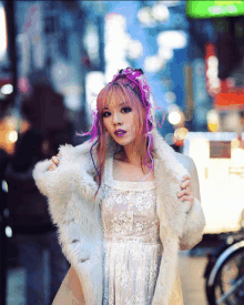 a woman with pink hair is wearing a fur coat