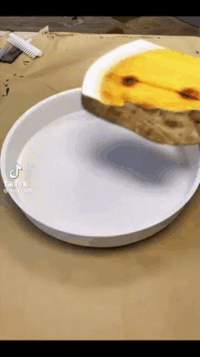 a tiktok video shows a slice of bread being poured on a white plate