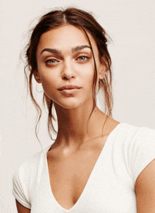 a close up of a woman 's face wearing a white t-shirt