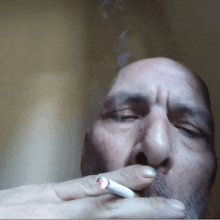 a man with a beard smoking a cigarette with smoke coming out of his mouth